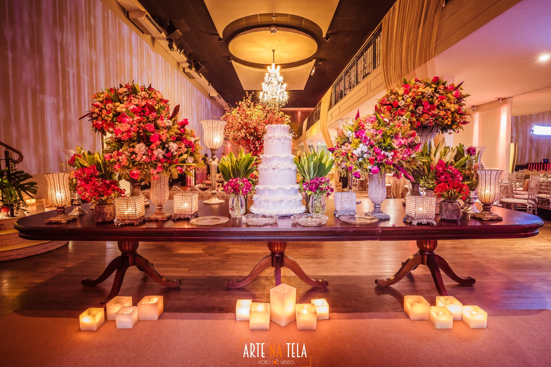 Mesa de bolo clássica com arranjos florais e velas