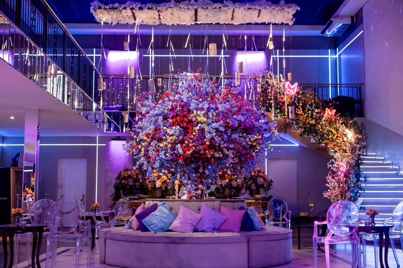 Salão decorado com flores e iluminação cênica no Buffet Fernandes